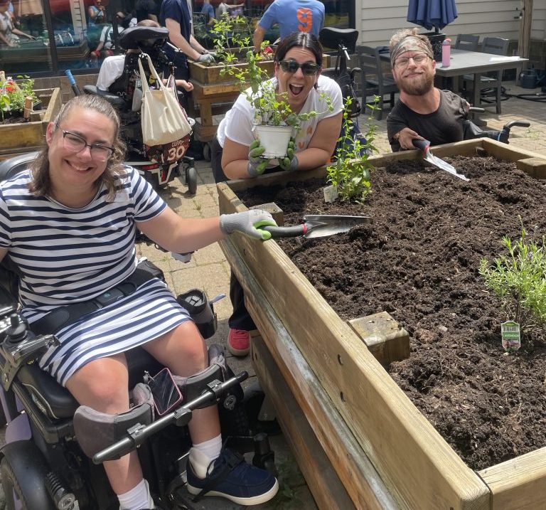 Sara, Ellen, and TJ plant vegetables.