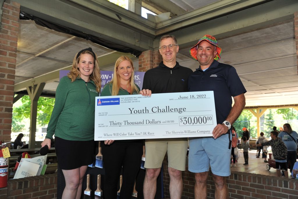 4 people holding a big check made out to Youth Challenge