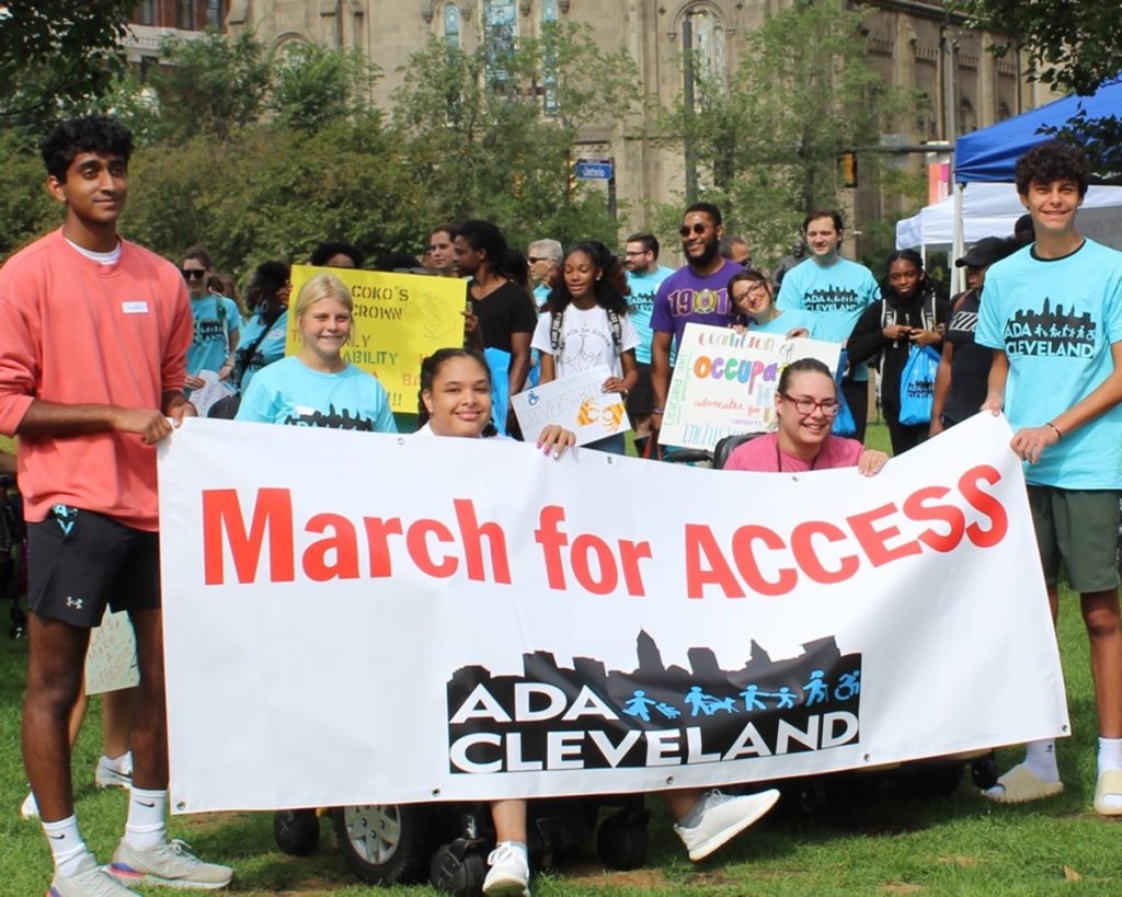 a group of people holding a big sign saying March for Access