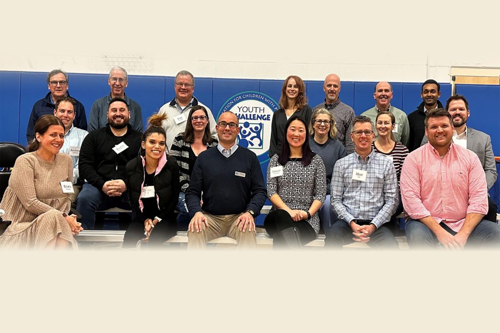 a group of people sitting in a gym posing for a photo