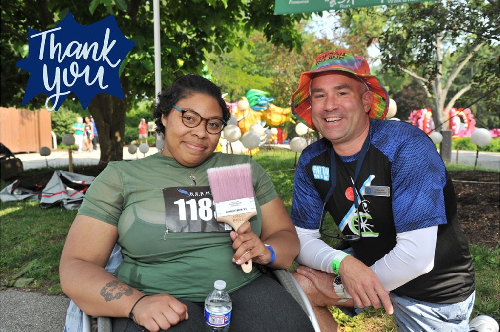 A woman in a green shirt sitting next to a man in a hat and a blue shirt