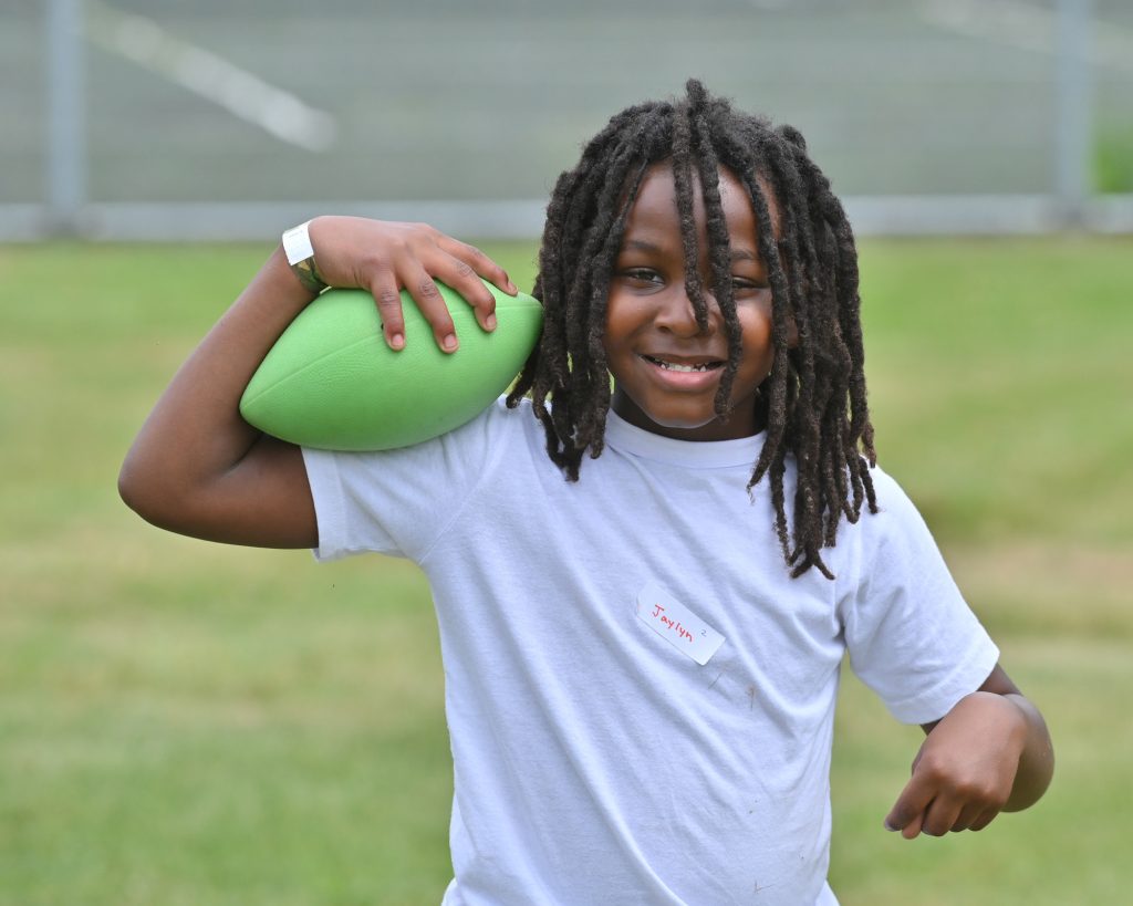 Closeup of a boy holding a green football