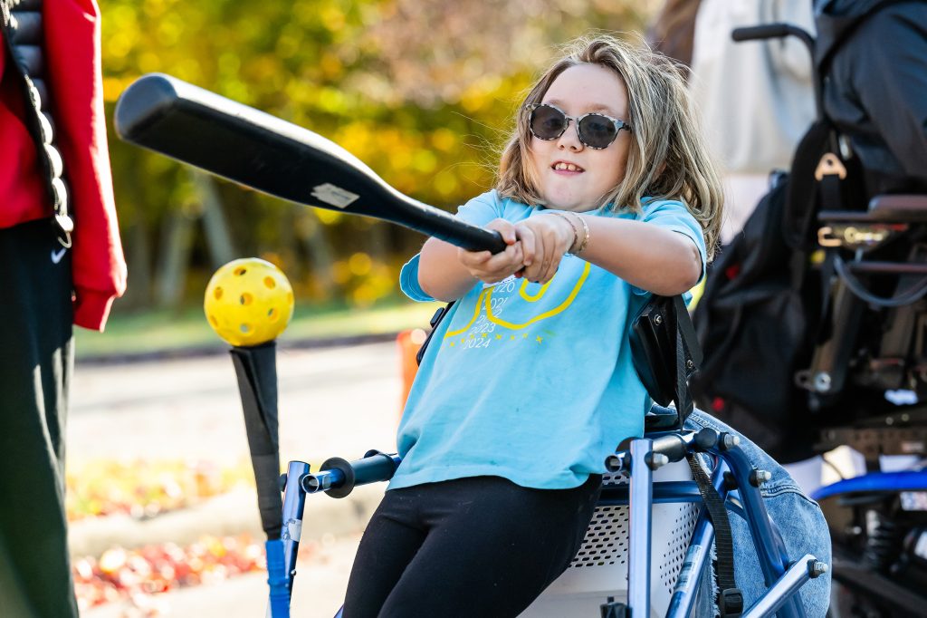 Girl in wheelchair playing teeball