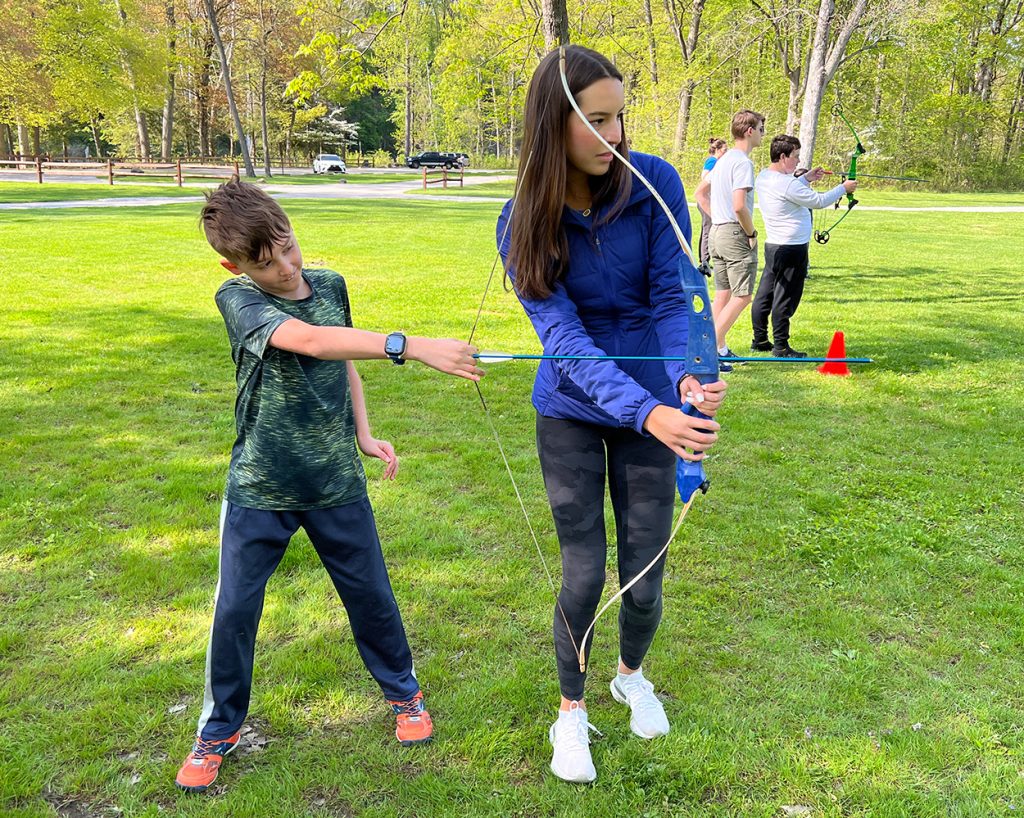 Girl and kid doing archery together