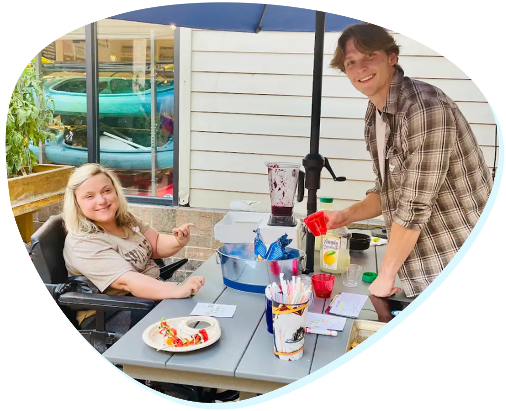 A lady sitting at a table and a man standing across from her