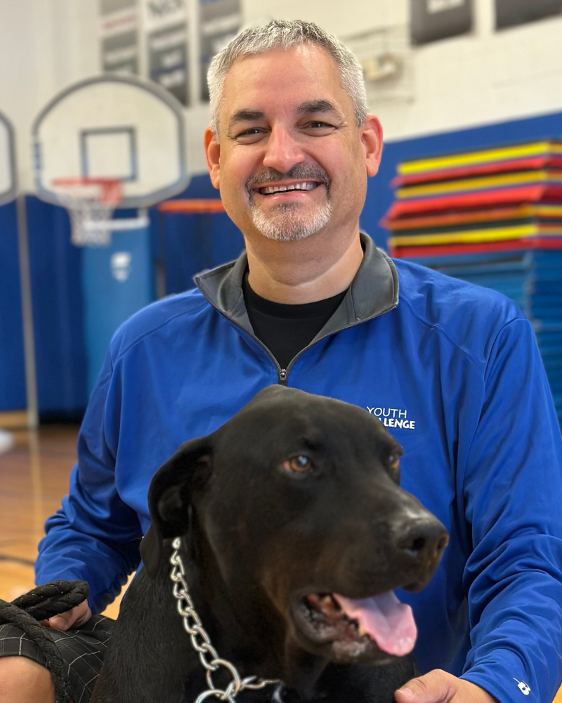 Ivan grieve sitting for photo with a black lab dog