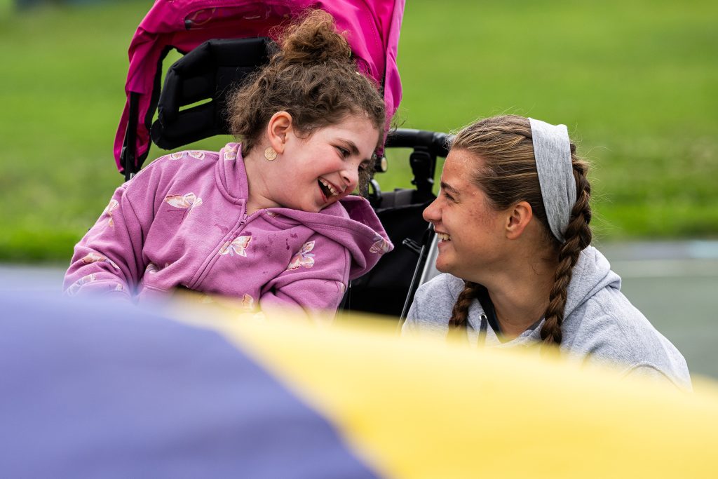 A girl and a teen looking closely at each other smiling
