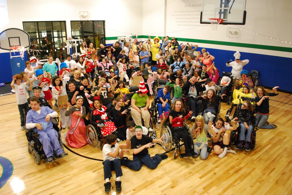 A large group of people in a gum posing in Halloween costumes