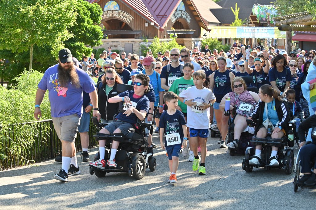 Runners, including several participants and alumni, do the 1-mile walk & roll at a previous Where Will Color Take You?
