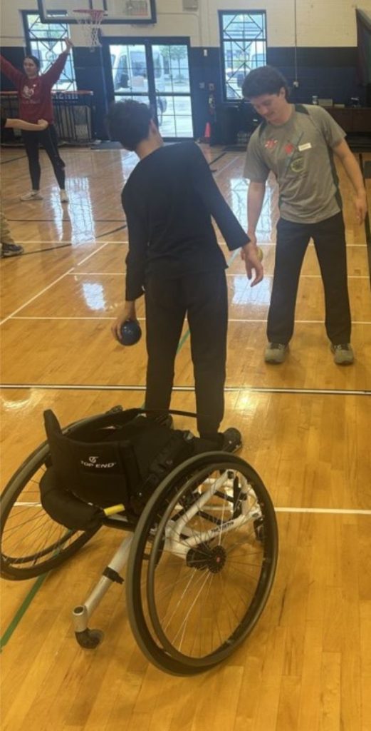 Immanuel exercises with weighted ball and staff member in front of him