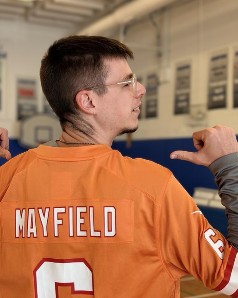 Noah standing with his back to the camera with a Baker Mayfield Jersey
