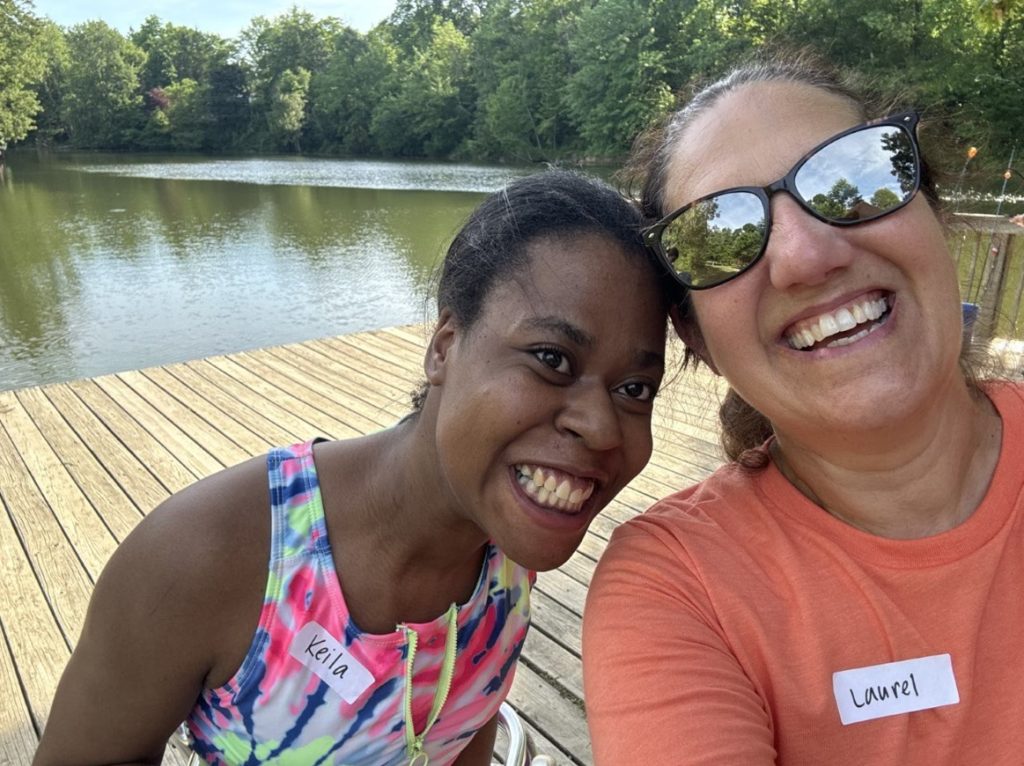 Participant and staff member smile together.