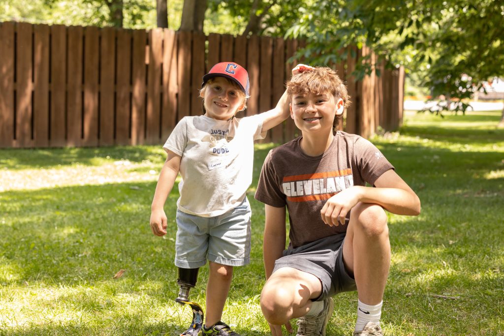 Two boys smiling in the grass