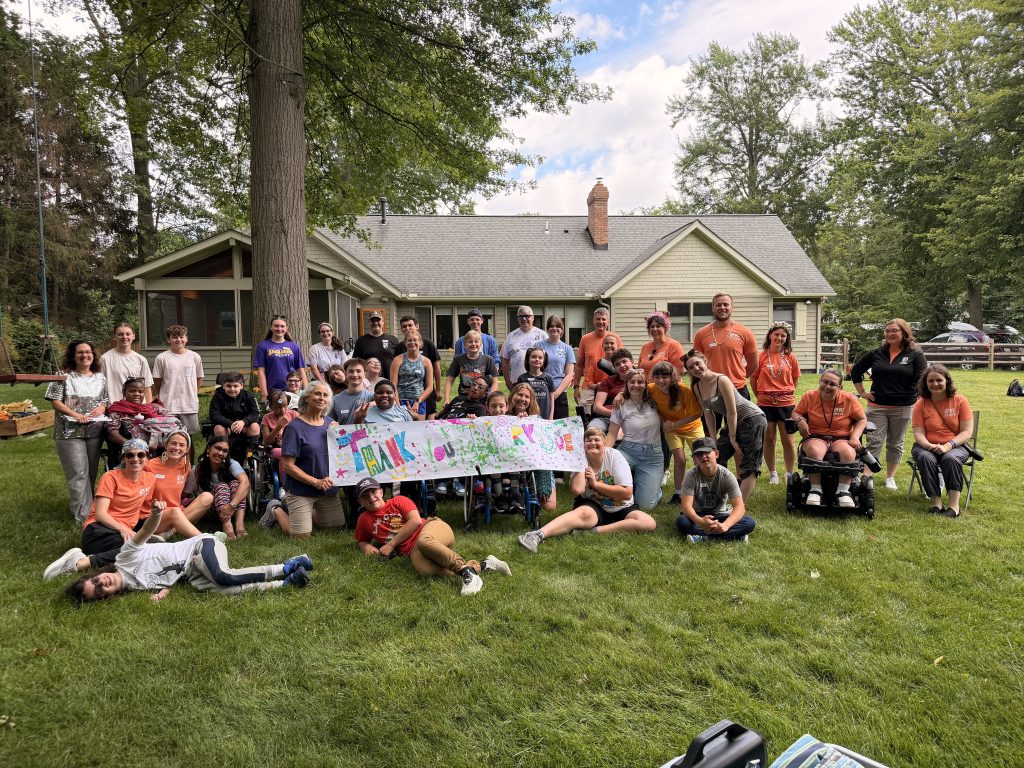 Participants, staff and volunteers pose with Mary Sue thank you banner.