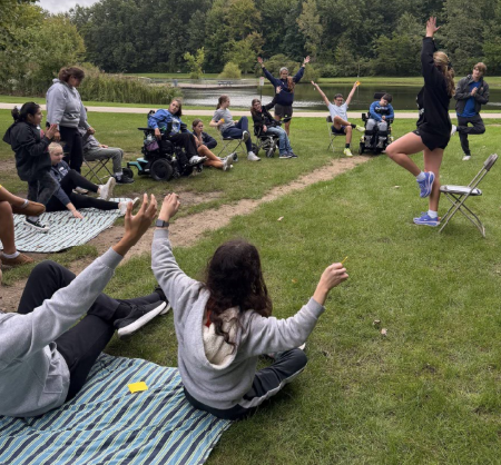Londyn leads YC's participants and volunteers in adaptive yoga.